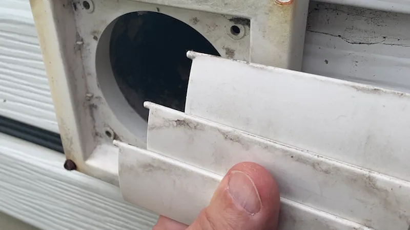 Hand opening an outside clothes dryer vent