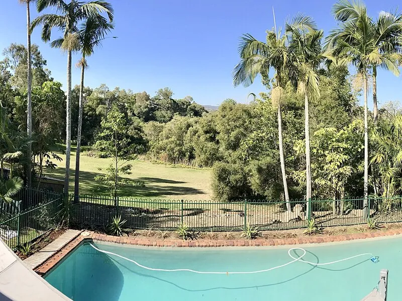 Backyard swimming pool beside a house