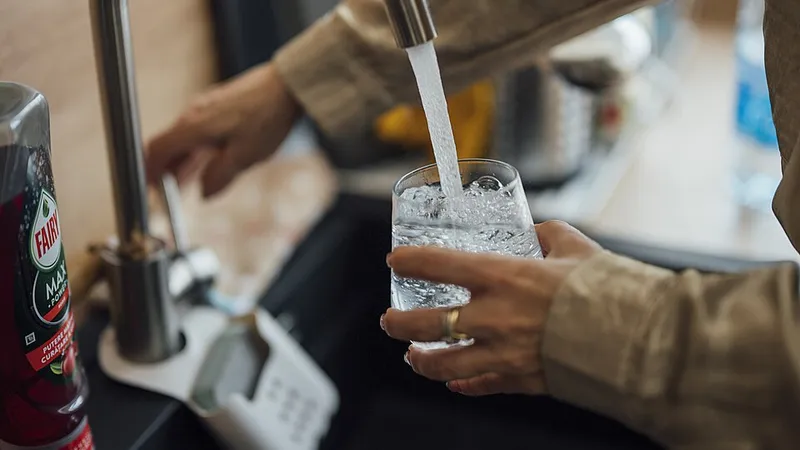 Filling a glass with filtered water at a kitchen sink